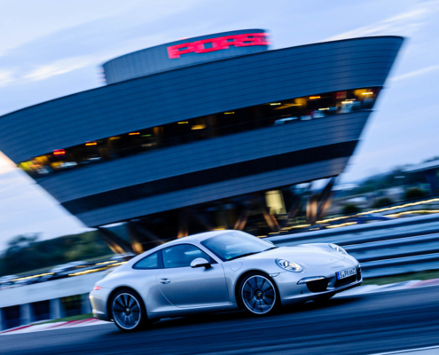 Ein Porsche fährt auf der Testrecke von Porsche Leipzig mit hohem Tempo entlang
